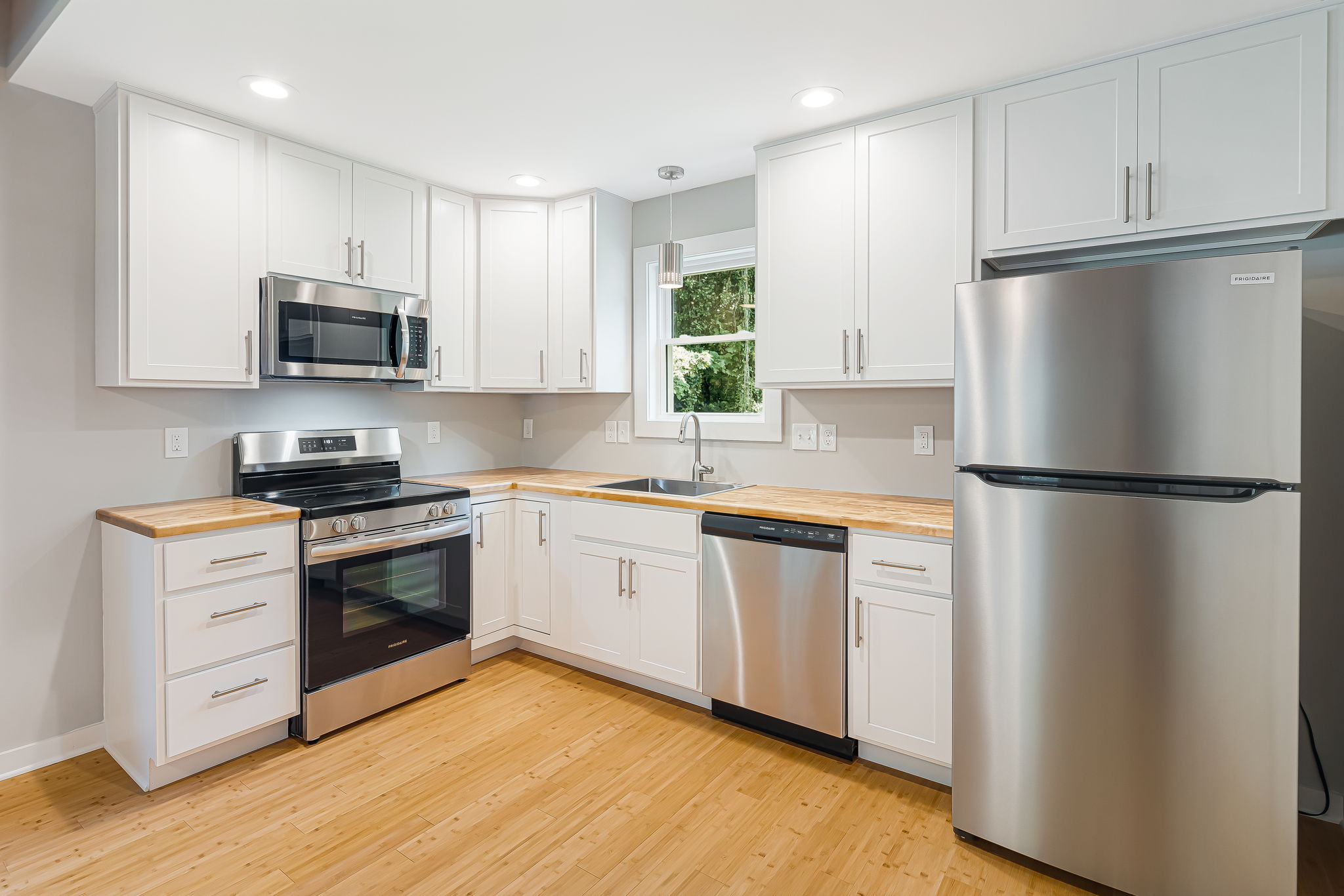 Budget Cottage 2 Bed — kitchen with white cabinets and butcher-block counters